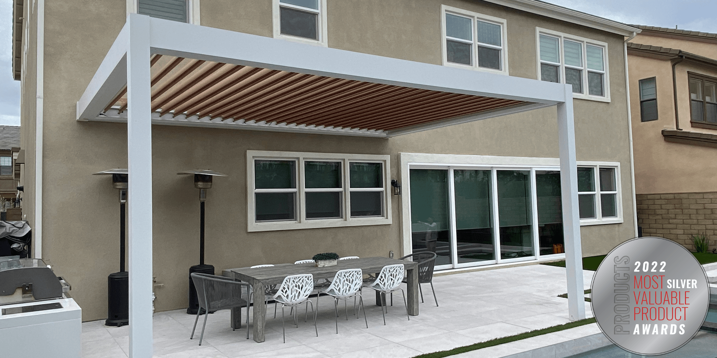 A white pergola with a table for 8, outside a tan house. Plus, 2022 Most valuable product silver award