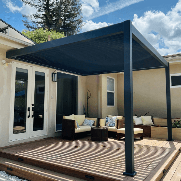 A black pergola outside a tan house